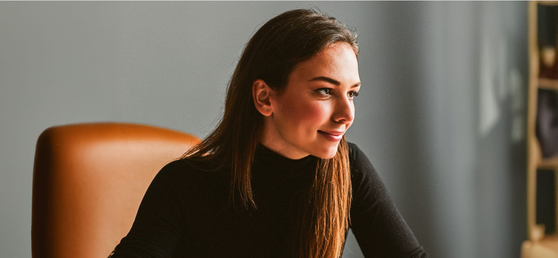 woman sitting in a chair in an office looking at a computer